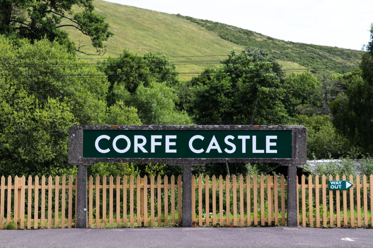 Corfe Castle railway station sign in front of Purbeck Hills