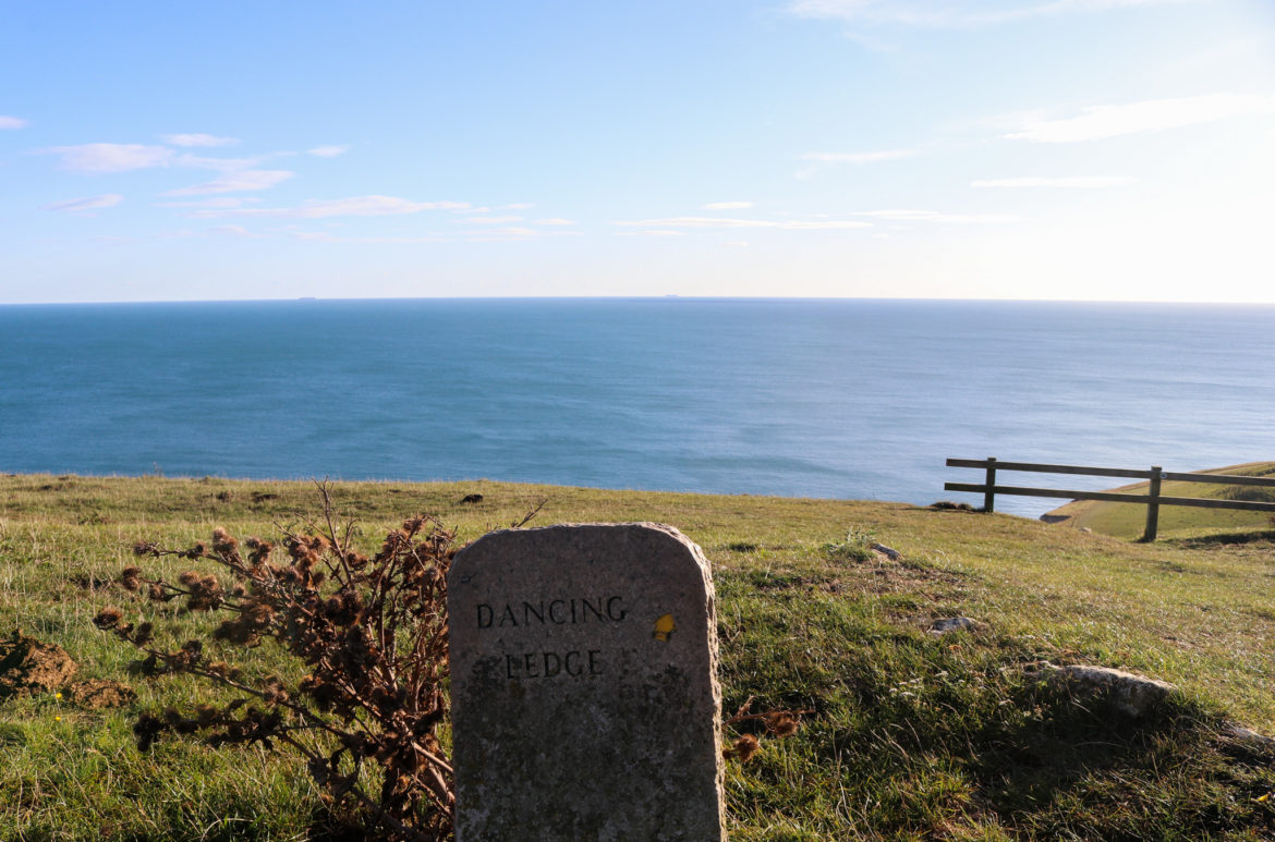Stone sign at Dancing Ledge overlooking the sea