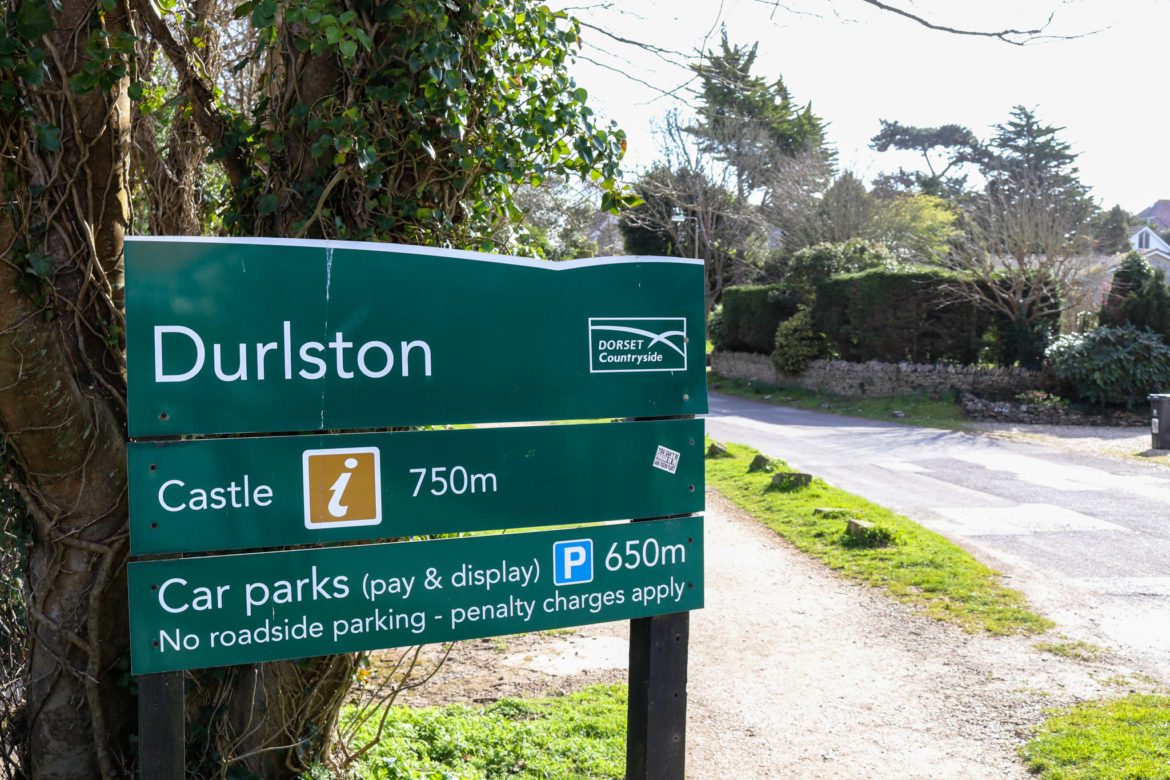 Welcome sign for Durlston Country Park near the woodland entrance 