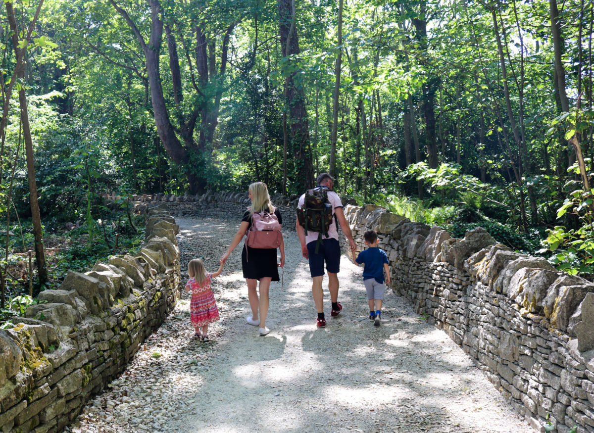 Family walking through a woodland path at Durlston Country Park