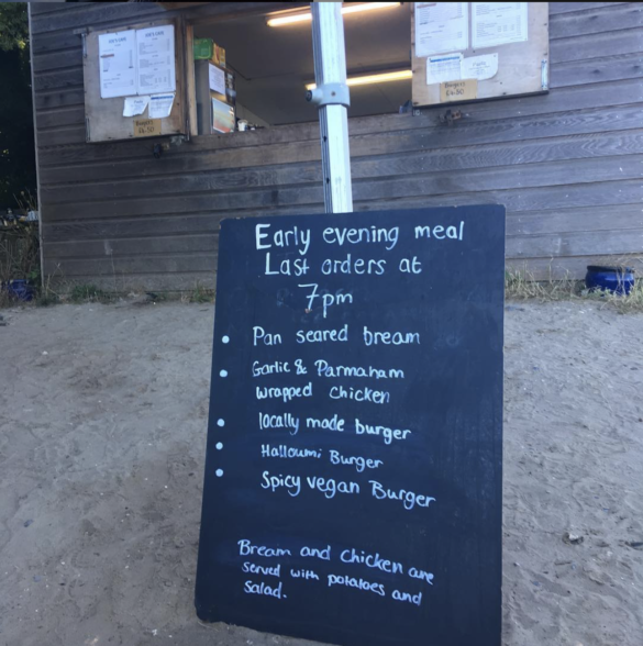 Evening meal menu board outside cafe hut on Studland's South Beach