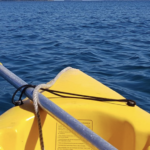Yellow kayak and oar on sea