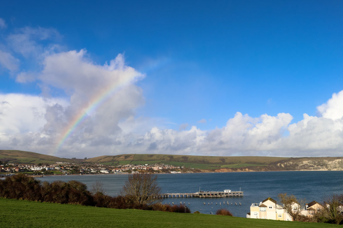 View of Swanage Bay from the Downs with a rainbow in the sky