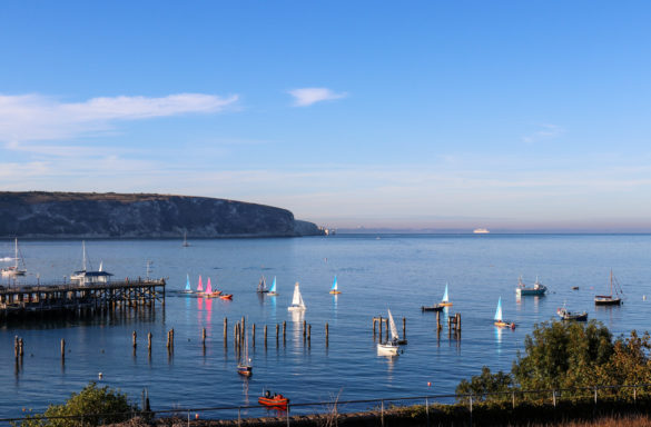 Sailing boats on the water by Swanage Old Pier