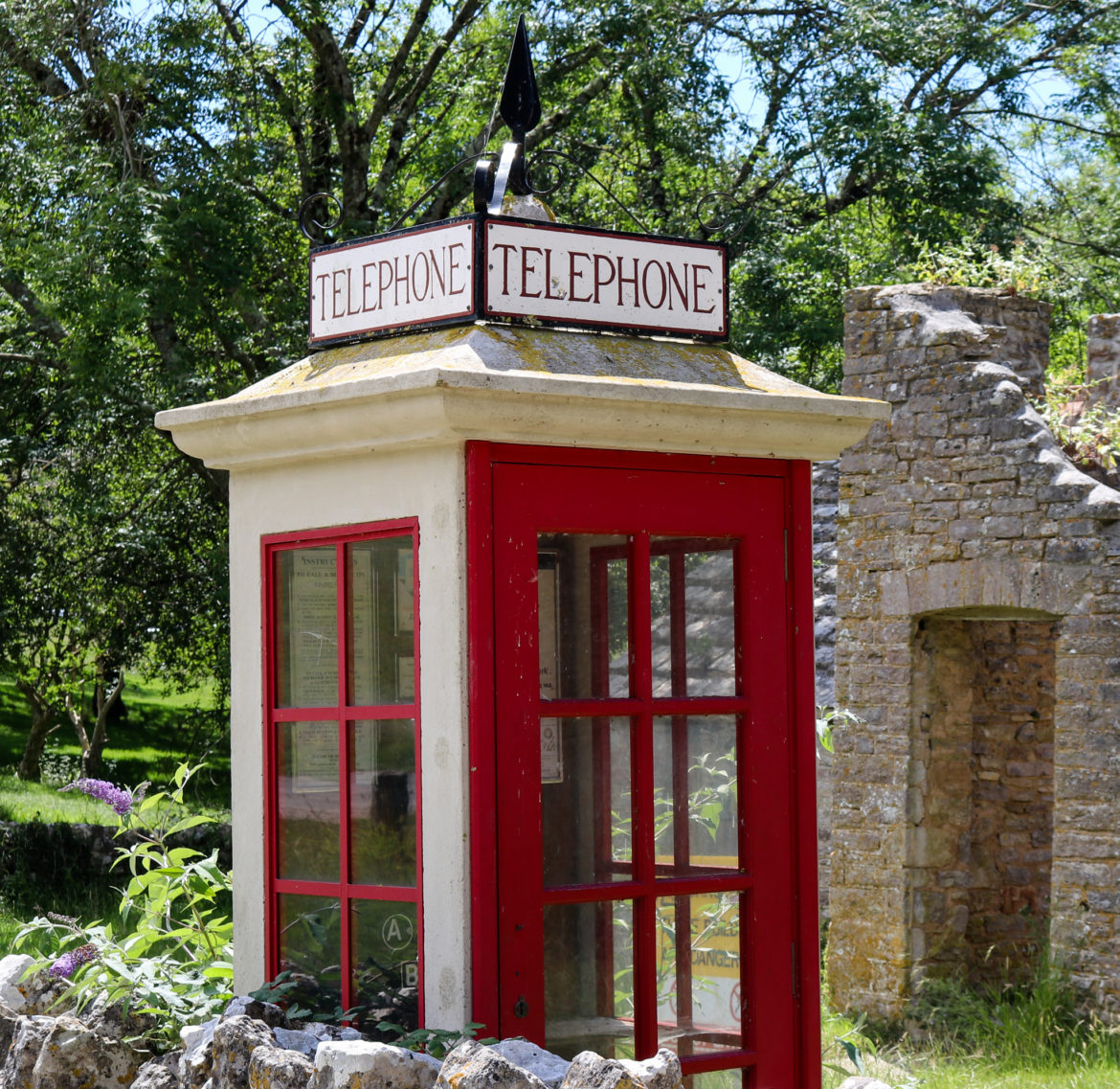 Red and white vintage telephone box replica in Tyneham village