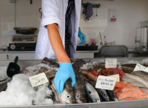 Fishmonger reaching for fish at market