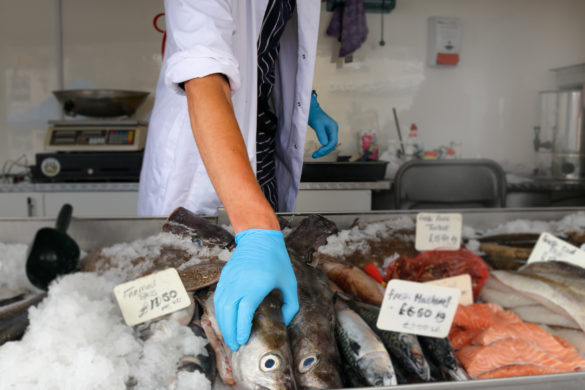 Fishmonger reaching for fish at market