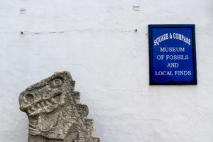 Dinosaur sculpture and Worth Matravers fossil museum sign