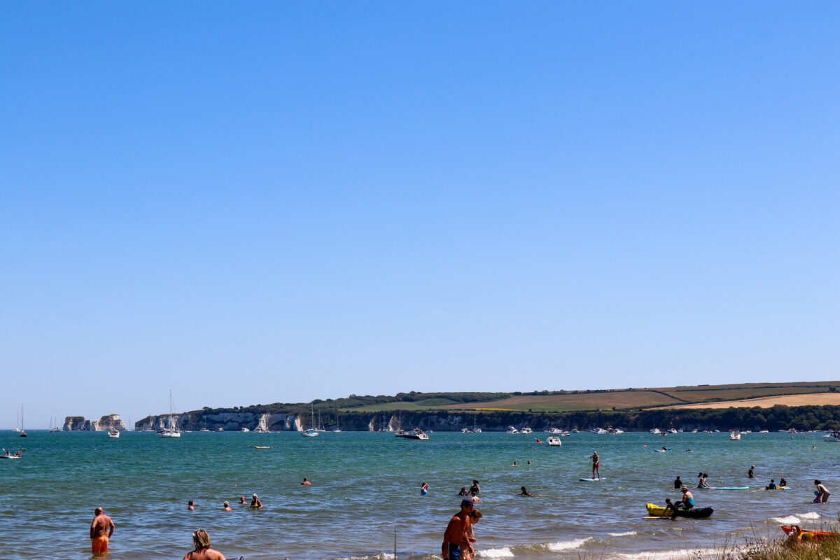 People on Knoll Beach with old Harry Rocks in background