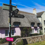 Pink thatched cottage and road signs in Wareham