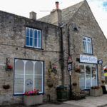 Exterior of Corfe Castle village store with church behind