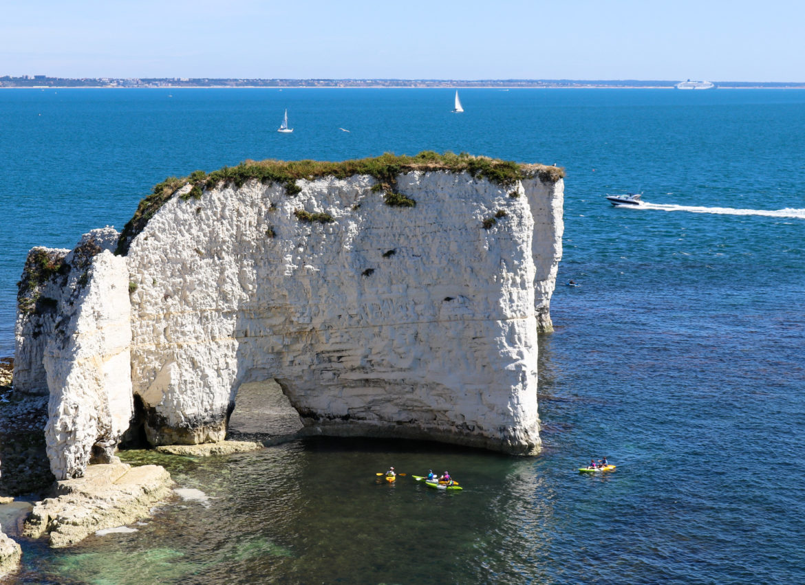 Kayakers at Old Harry Rocks' arch and kayakers