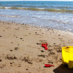 Yellow bucket and red spade at North Beach in Swanage