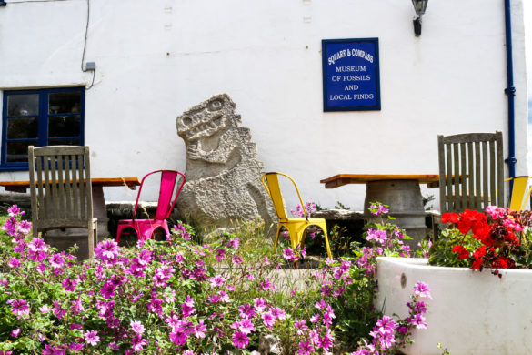 Colourful chairs and stone-carved dinosaur outside the Square and Compass museum, Worth Matravers