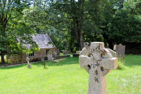 Headstone at Tyneham with schoolhouse in background