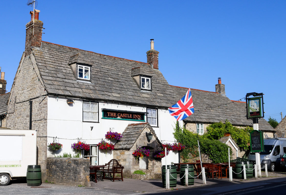 British flag and hanging baskets outside the Castle Inn pub in Corfe Castle