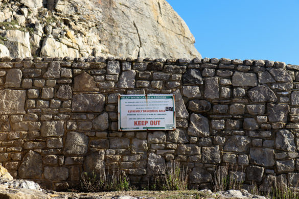 Keep Out warning sign on stone wall at Durlston's Tilly Whim Caves