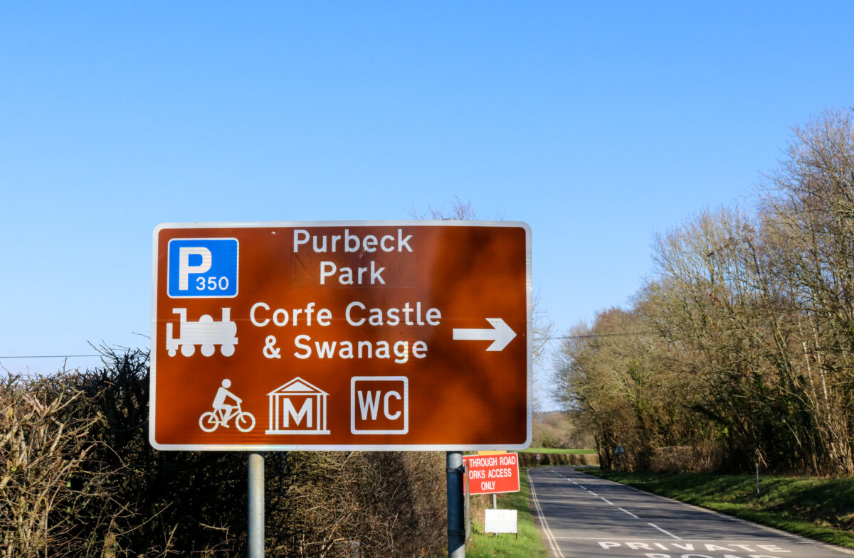 Brown sign for Purbeck Park and trains to Corfe Castle and Swanage