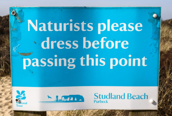 Sign reminding naturists to dress when leaving Studland Naturist Beach