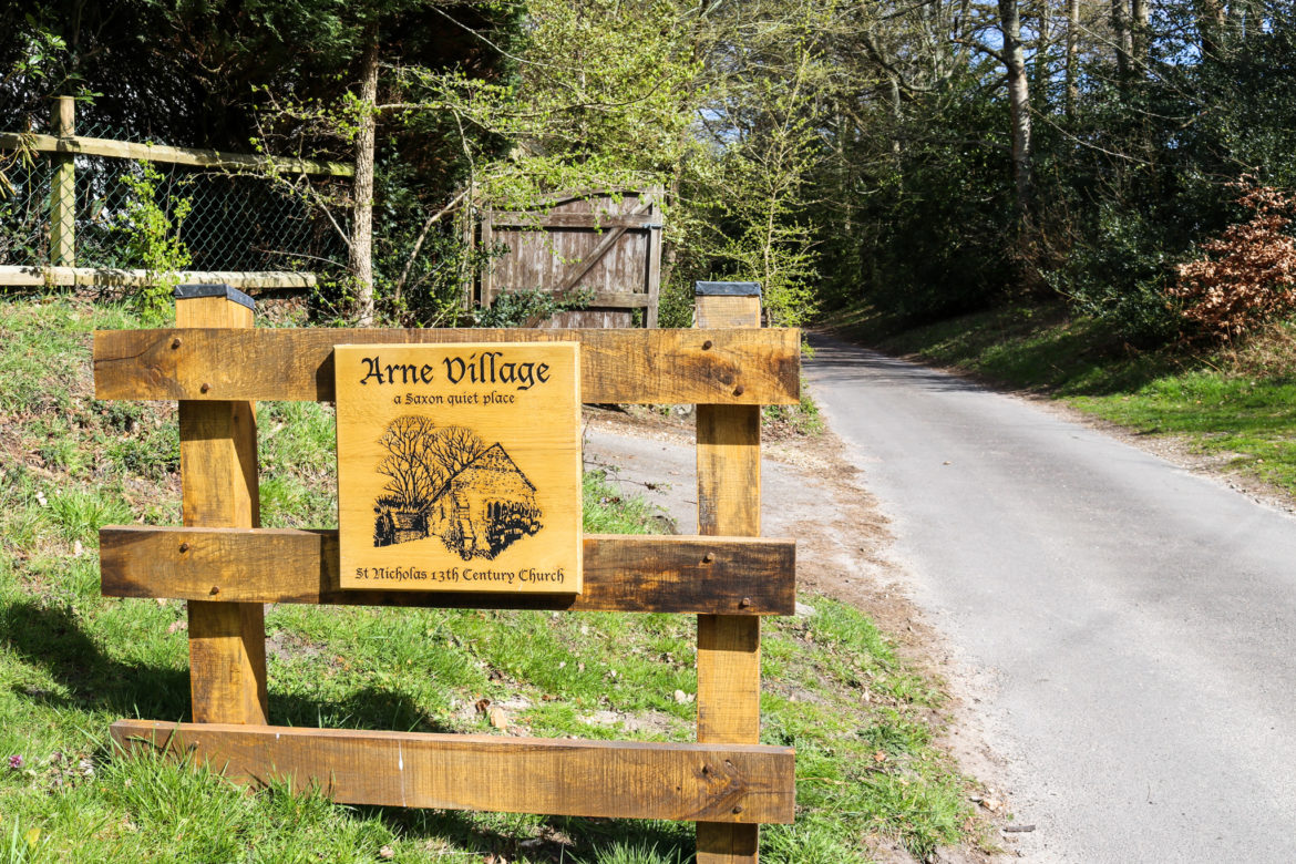 Wooden sign for Arne Village a Saxon quiet place