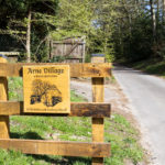 Wooden sign for Arne Village a Saxon quiet place
