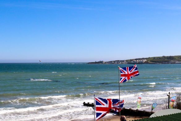 British flags flying on Swanage beach outside The Cabin café