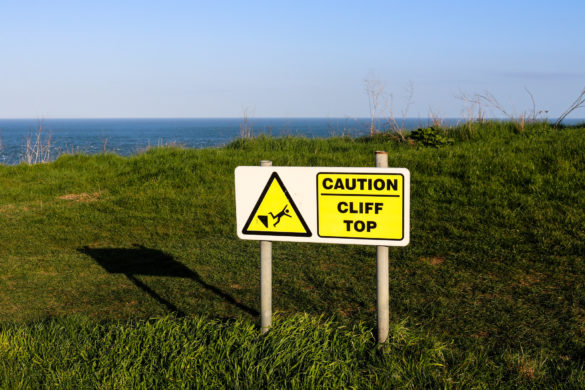Precarious cliff caution sign in Swanage up at The Downs