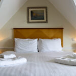 Folded towels on freshly made bed at the Grand Hotel in Swanage