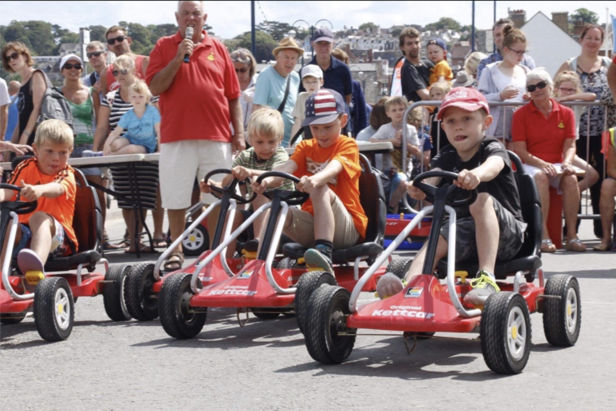 Boys racing along Shore Road in Swanage in pedal-push go-karts