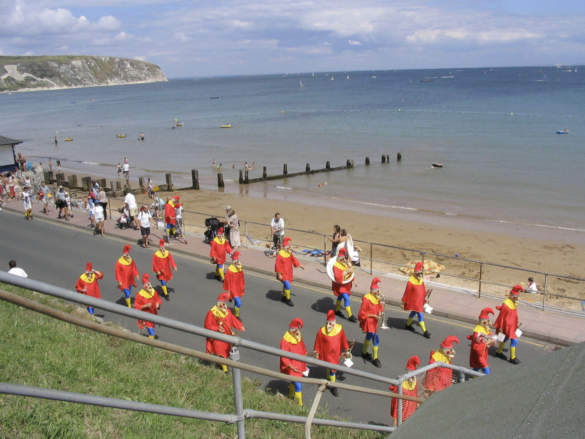 Group in Swanage Carnival parade going past the beach on Shore Road