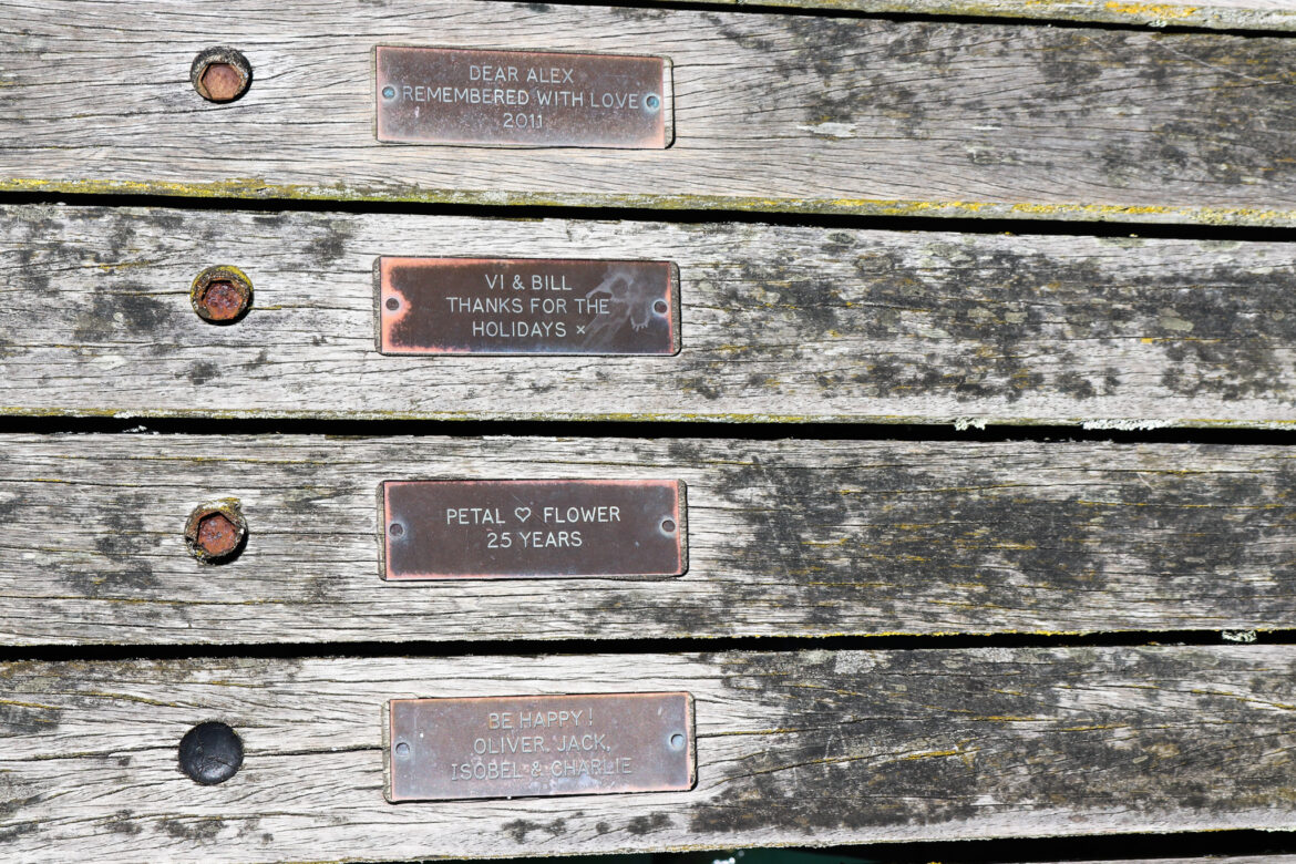 Celebratory and memorial plaques on the planks of Swanage Pier