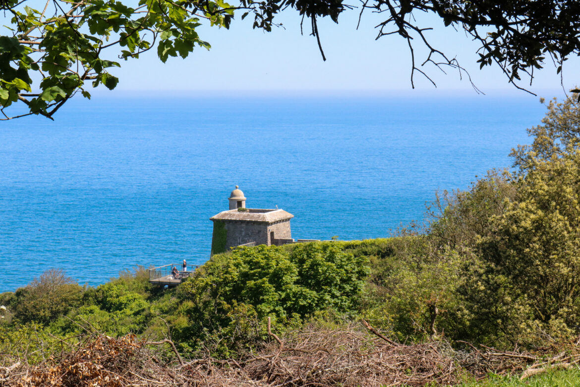 Turret of Durlston Castle seen from the path in the woods