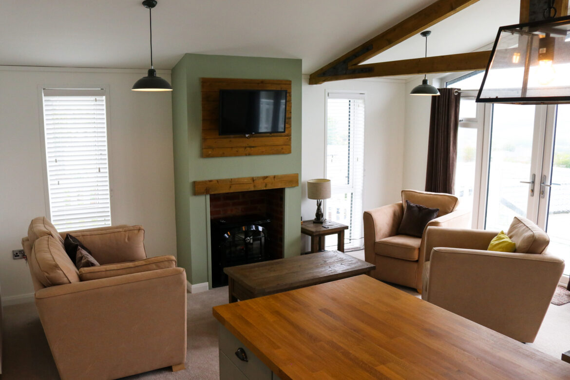 Living room space with TV, free and coffee table, Swanage Coastal Park