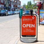 'Open' sign outside estate agents Goadsby, Swanage