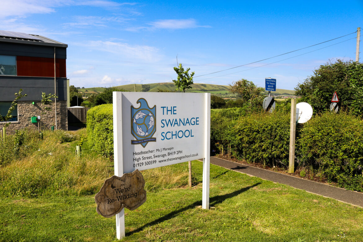 Purbeck Hills behind the sign for the Swanage School