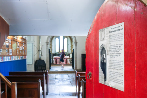 Church door opening onto pews at St Mary's, Tyneham