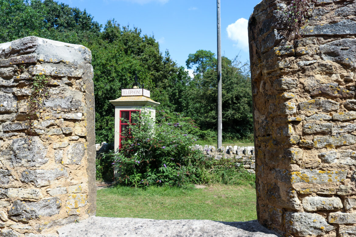 Old, replica phone box at Tyneham, through walls of cottage