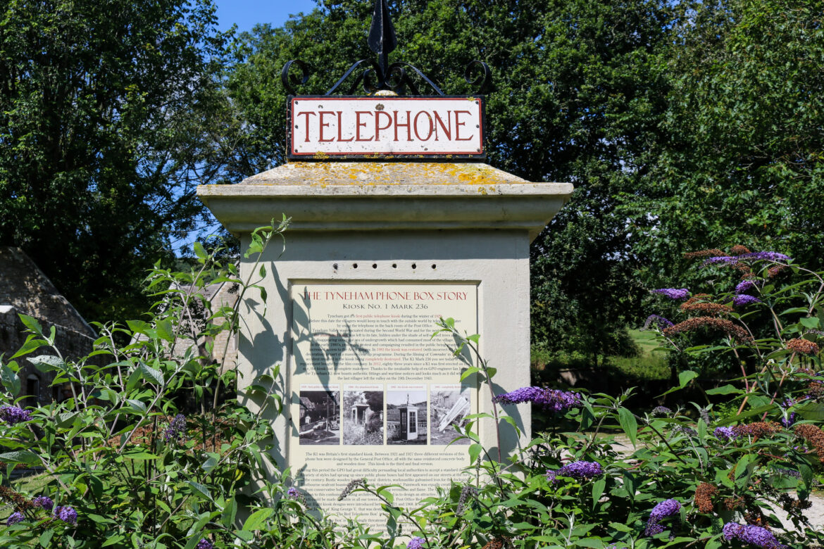 Flowers growing around the old, replica phone box in Tyneham