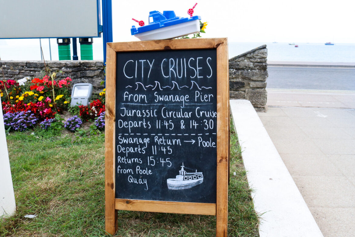 Depart and return times on a blackboard for Jurassic Circular Cruise from Swanage Pier