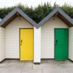 Red, yellow, green and blue doors on Swanage's Shore Road beach huts
