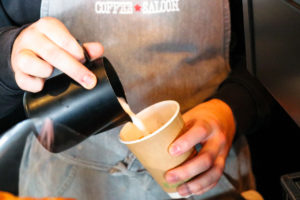 Person making a takeaway coffee in a Purbeck café
