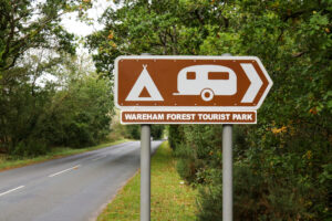 Brown tourist sign for Wareham Forest camping and touring park on the Bere Road
