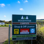 Sign outside Woodyhyde Campsite for its shop and off license and 3 star AA award