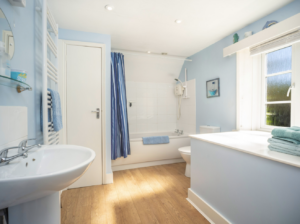 Bright bathroom with wooden floors at Norden Farm's cottage holiday let