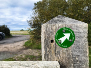 Sign on gatepost for Poole Harbour walking trail near Hartland Stud
