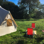 Camping chairs outside bell tent at Steeple Leaze Farm Campsite