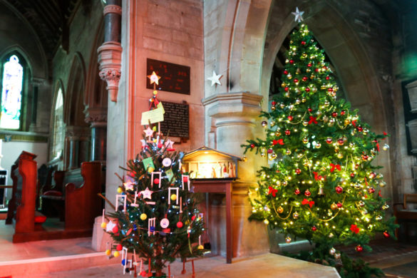Decorated Christmas trees by the nativity display in Langton's St George's church