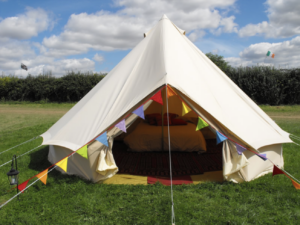 Bell tent with colourful bunting at Swanage Bijou Glamping
