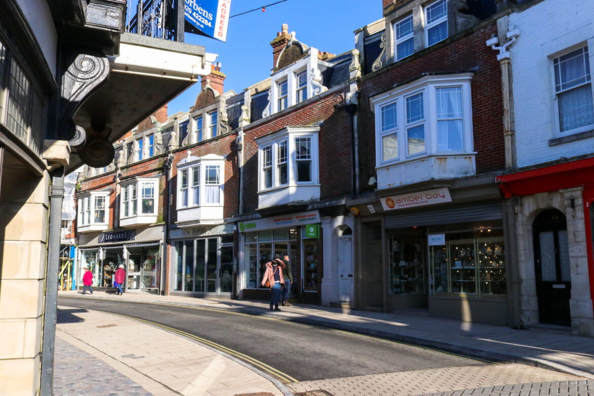 People walking by the shops in Swanage's Institute Road