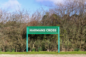 Green station sign at Harman's Cross railway station in Purbeck